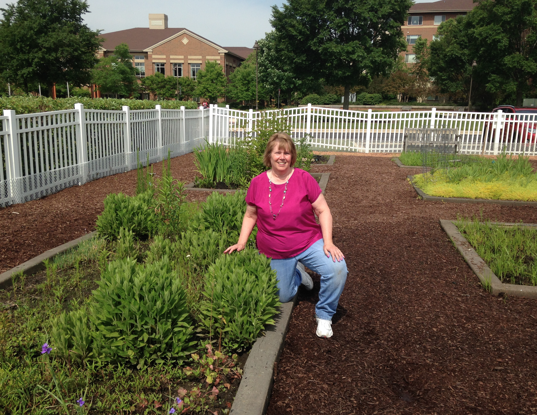 Jan Parks poses next to the garden beds