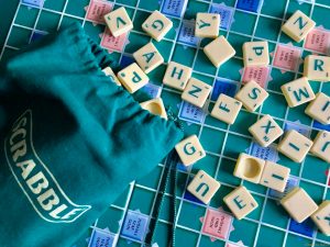scrabble tiles spread across a board. Scrabble makes an excellent brain game for seniors by exercising language and memory